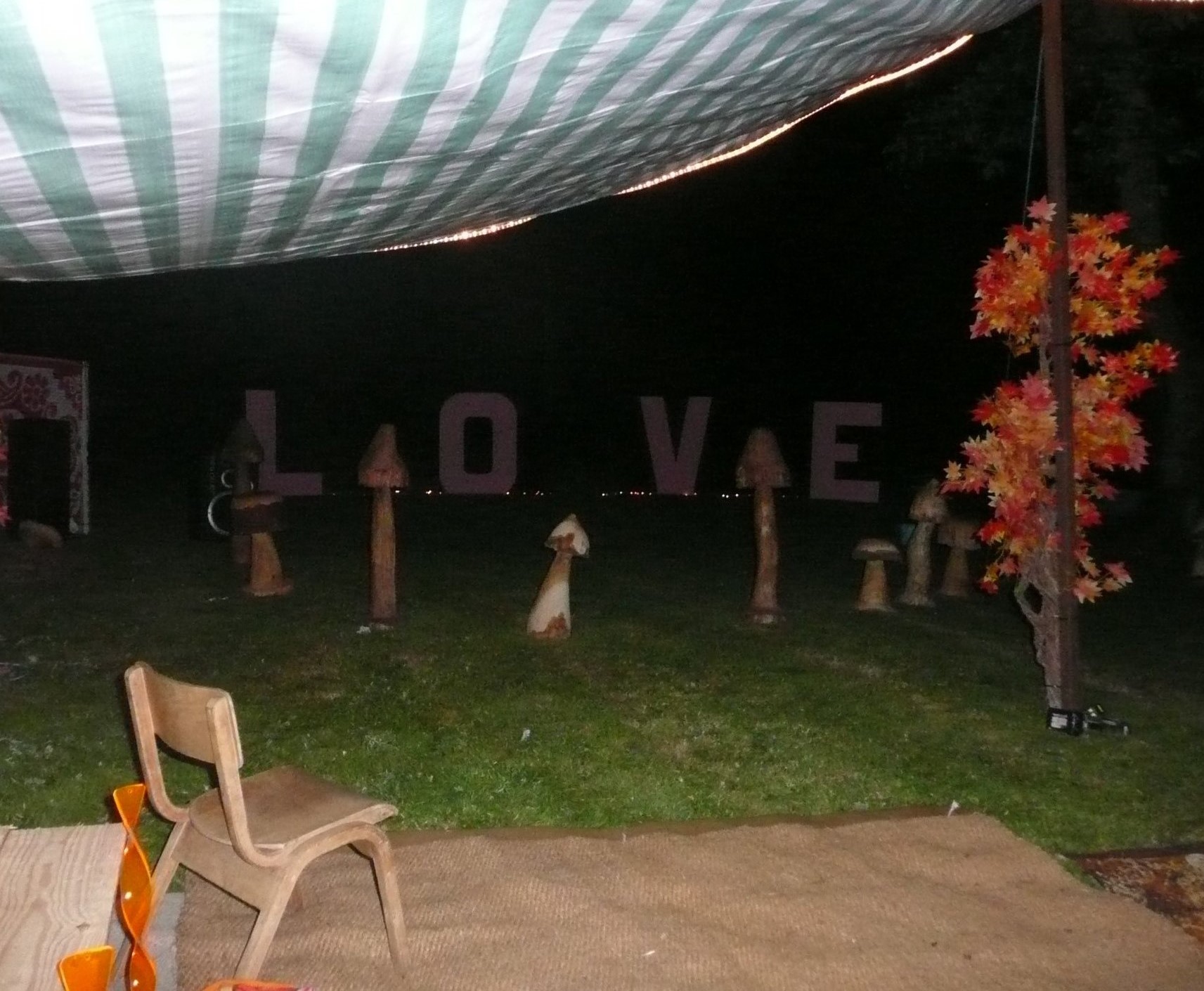 Camp setup with big love sign and wooden mushroom carvings